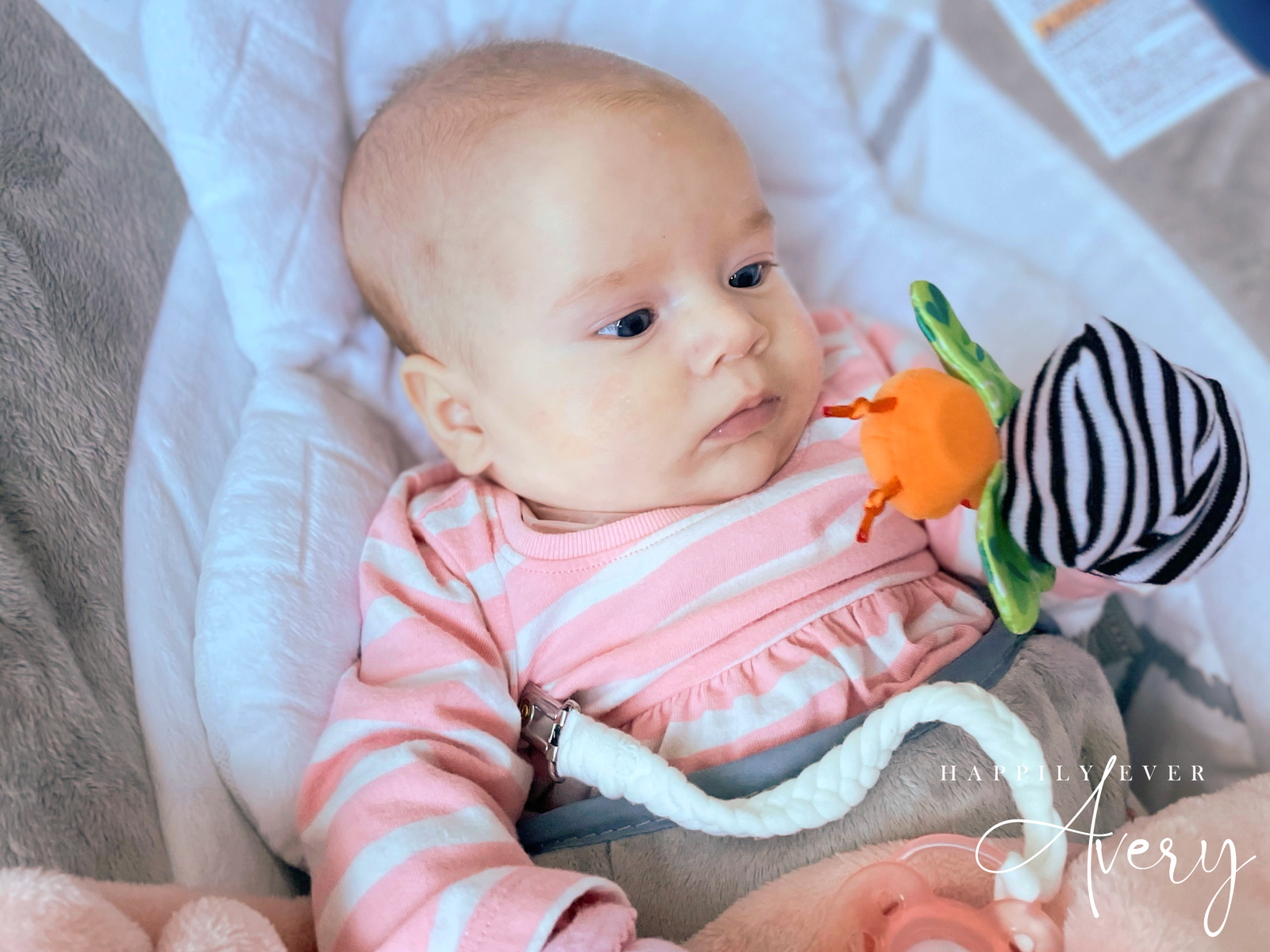 baby playing with wrist rattle