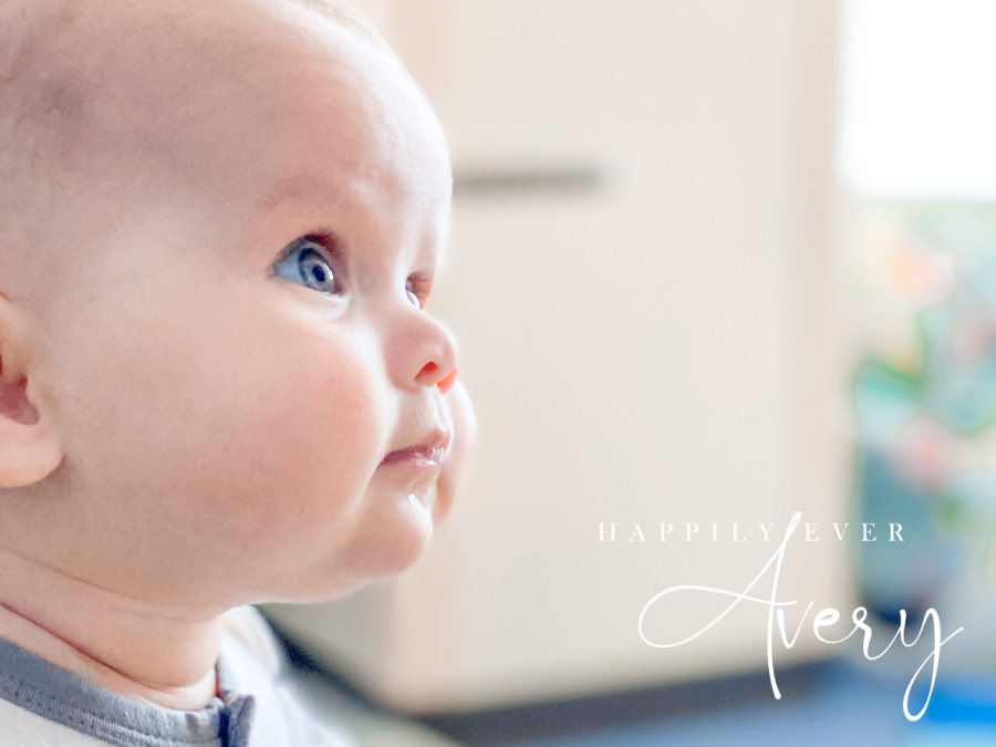 baby with blue eyes and big cheeks looking up
