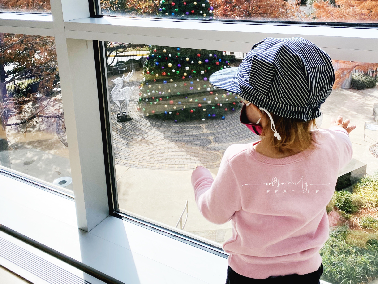 toddler looking at Christmas tree with mask on